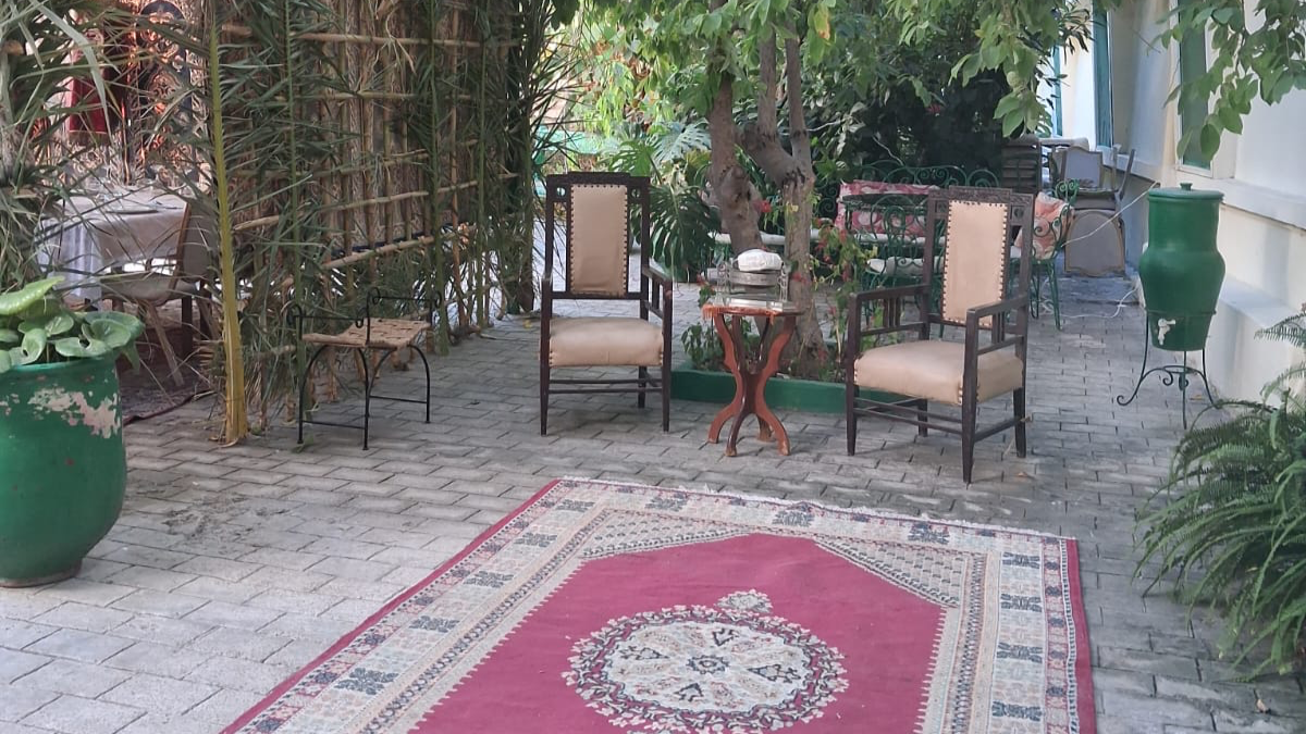 Fête de Souccot à la Résidence montrant la cabane rituelle en feuillages dans le jardin ombragé à côté des salons d'extérieur.